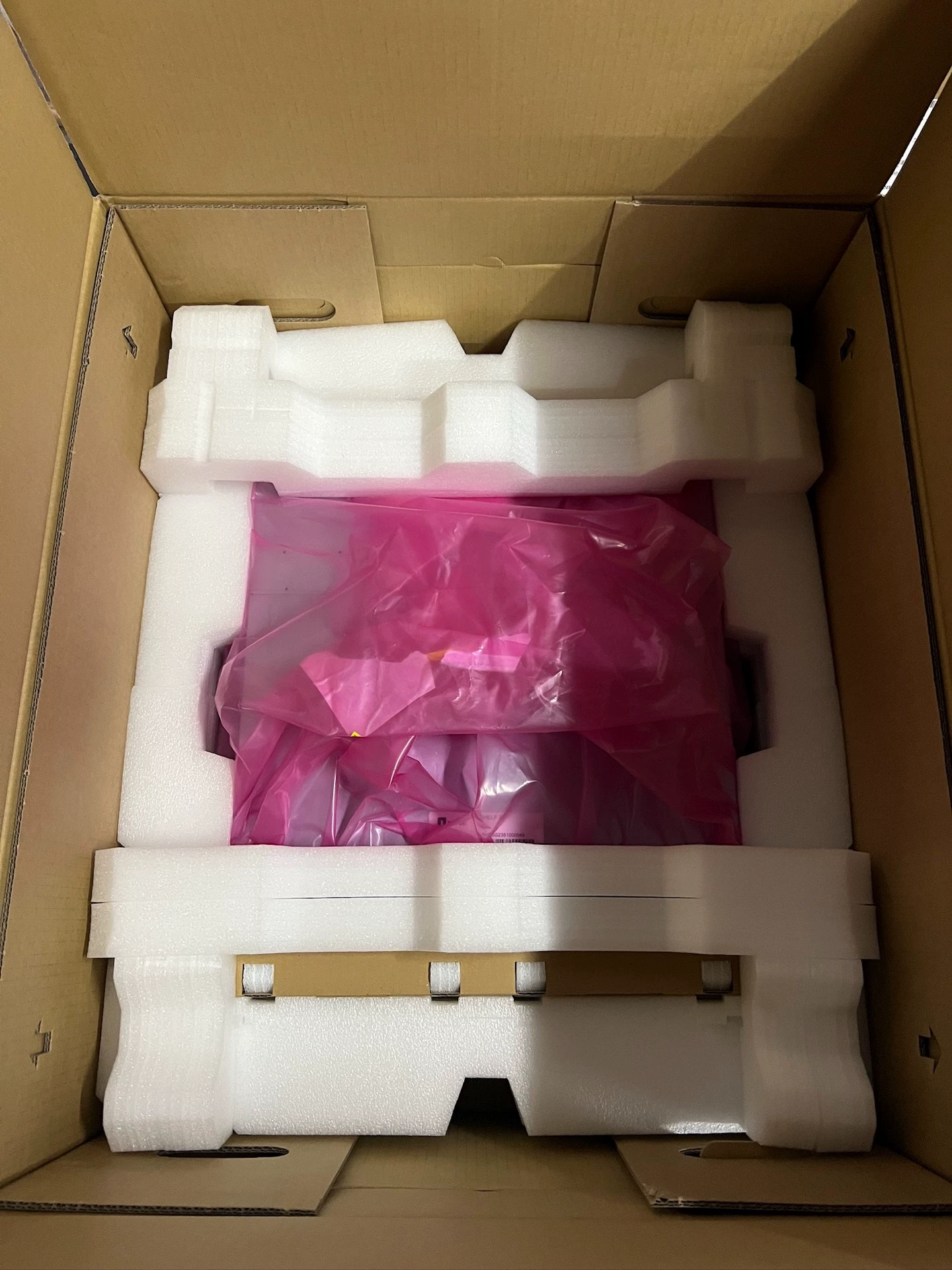 White formed foam supports surrounding the shelf inside its pink protective bag.