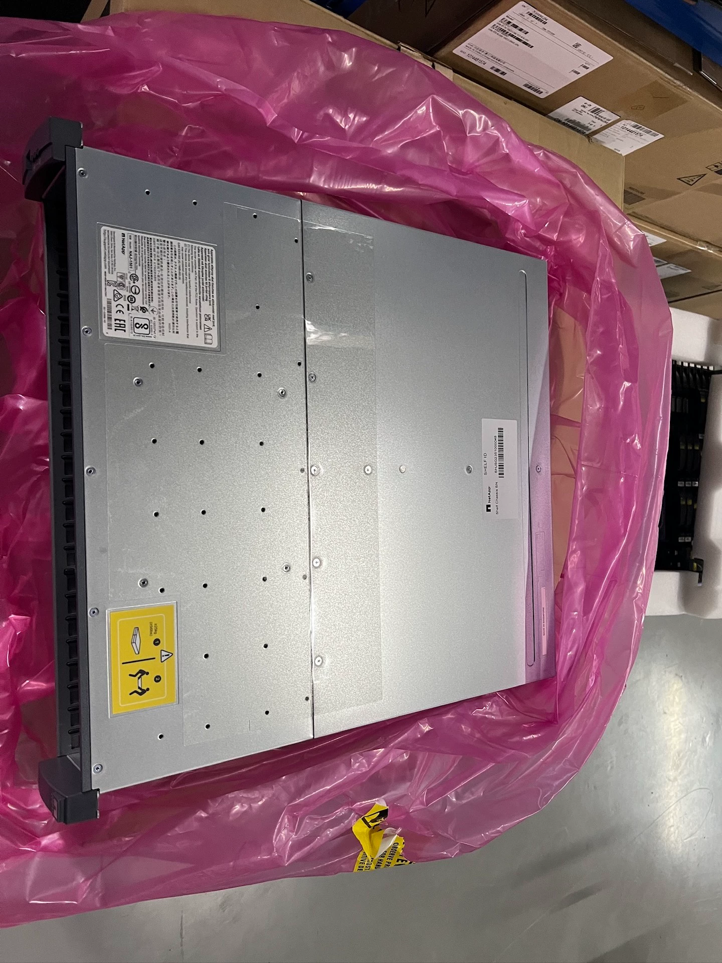 Top-panel labels and the transparent protective film visible over the metal surface.
